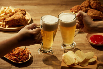 Drinking beer with fried potatoes spicy chicken floss and fried chicken in brown background , mug...