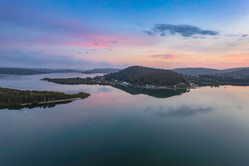 Soft and peaceful sunrise aerial waterscape with clouds and reflections