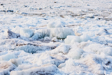 Ice structure of river hummocks in spring. Sharp ice needles on the banks of the Amur River. Selective focus. Blagoveshchensk, Russia.