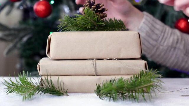 zero waste christmas gift decorated pine cone and fir branch with craft paper, no plastic holidays with lights garland christmas tree at home.