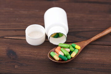 Open the white medicine bottle and put the capsule in the spoon