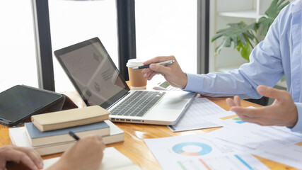 Brainstorm team, Marketers and financial accountants are discussing and analyzing charts to plan strategies to meet customer needs, Using graphs and laptops to analyze business data, Meeting concept.