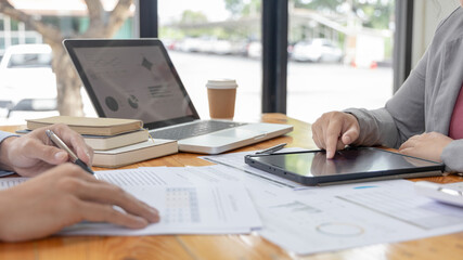 Fototapeta premium Brainstorm team, Marketers and financial accountants are discussing and analyzing charts to plan strategies to meet customer needs, Using graphs and tablet to analyze business data, Meeting concept.