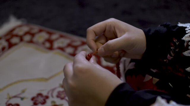 Close shot of hand of a Muslim girl counting beats for praying to gods.