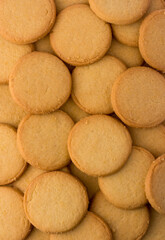 milk biscuits background, crispy and crunchy round crackers, tea time snack taken from above, closeup flat lay