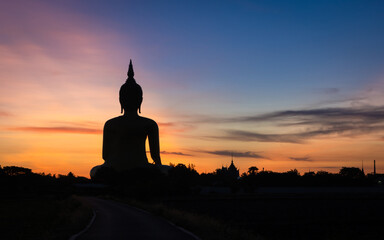 Big Golden Buddha statue with morning sunrise at Wat Muang Temple famous place of religion is respected worshiped in Thailand.
