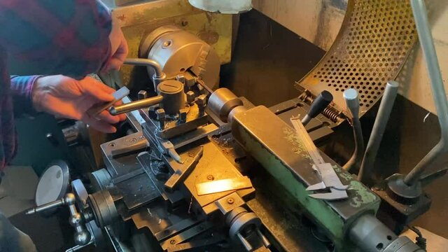 a man works on a lathe in a workshop. men's hands men's work lathe industry parts manufacturing soviet machine ussr