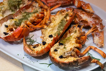Grilled Lobster with Truffle Sauce served on a white plate.