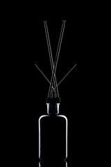 Still life with glass object and metal antenna on a black background