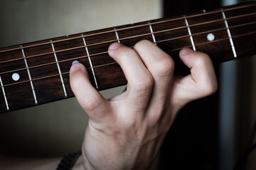 Hand playing on a guitar.