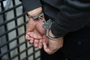 A police officer handcuffs a suspect