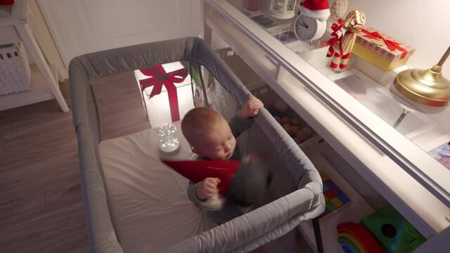 Charming cute toddler have fun spend New Year time, kid taking out a christmas present from the table. Holiday season. Merry Christmas. High quality 4k footage