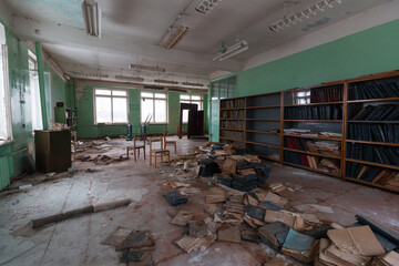 abandoned school classroom with tables and shelves