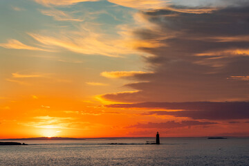 Spectacular sunrise clouds over Ram Island Ledge Lighthouse in Portland, Maine, USA
