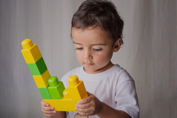 portrait of a little boy playing with building blocks