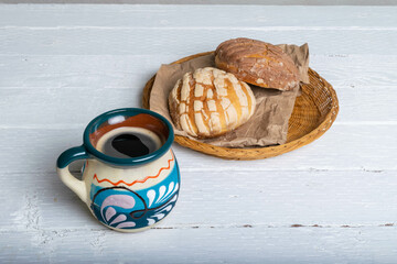 traditional cup of Mexican coffee and bread shells of chocolate and vanilla