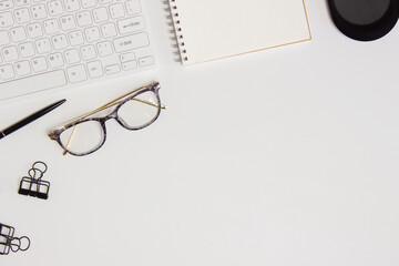 Working items with keyboard, notebook and glasses over the white background. 