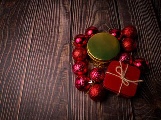 Christmas red ball and gifts box on a wooden table. Holidays christmas background. Copy space for text or design.