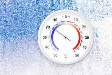 Celsius scale thermometer on a frozen window shows minus 18 degrees