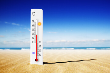 Hot summer day. Celsius scale thermometer in the sand. Ambient temperature plus 20 degrees