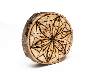 burnt pattern on round cut of a tree isolated on a white background. A flower burned on a tree