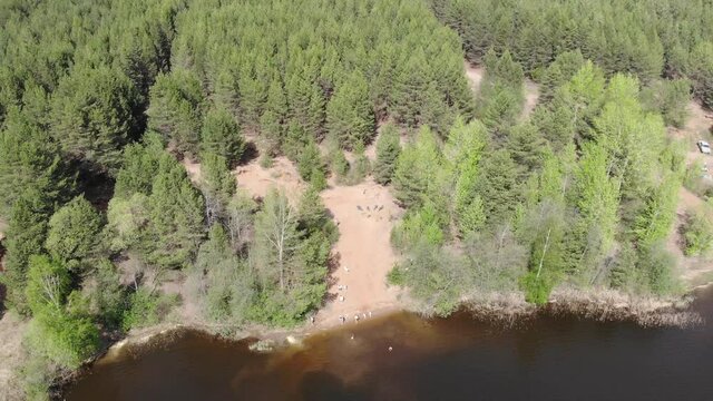 Aerial view of the bank of a quarry and floating people (Strizhi, Kirov region, Russia)