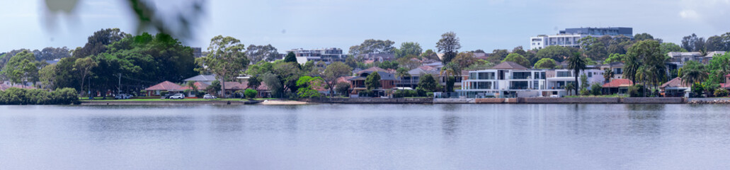 Fototapeta premium Panorama view of Concord Bay on Sydney Harbour NSW Australia, wealthy houses on the forshore nestled between lush green trees