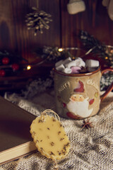 A fragrant sachet made of beeswax and a mug with cocoa on the background of a New Year's decor.