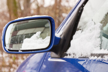 Car windshield and mirror covered snow. Winter problems