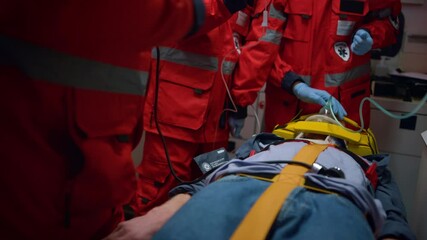 Unrecognizable ambulance doctors saving life of victim in emergency vehicle