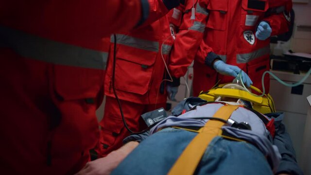 Unrecognizable ambulance doctors saving life of victim in emergency vehicle
