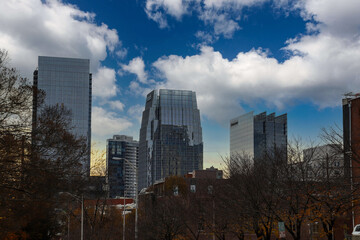 a stunning shot of the skyscrapers and the office buildings in the cityscape with blue sky and...