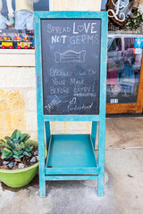Fredericksburg, Texas, USA. Chalkboard sign asking shoppers to wear masks. (Editorial Use Only)