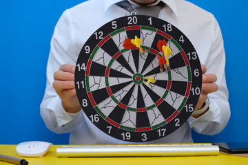 Dart board and a desk. Workspace with a target and a successful business growth concept, as well as...