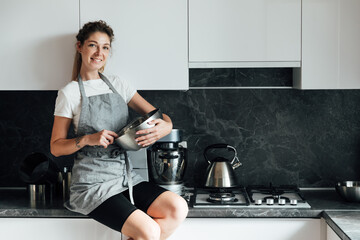 woman housewife prepares dessert sweet cakes in kitchen