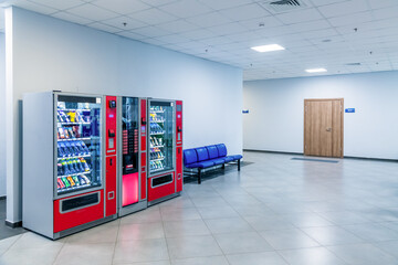 Group of red vending machines stands by the wall. Glare is reflected on a black screen. No people. Copy space for your text. Small business theme.