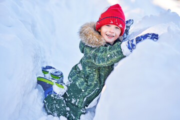 Happy kid having fun during winter snow