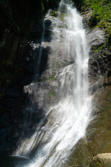 Mahuntseti Waterfall on a sunny, bright day. Georgia. Sights of Georgia. Vertical photo
