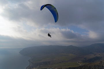 Paraglider high in the sky over the Black Sea coast. Crimea.