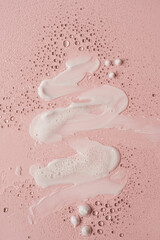 Beauty, skincare products setting. White cosmetic cream smear on neutral pink background. White...