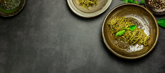 Homemade pasta spaghetti with basil pesto sauce and fresh basil leaves. Copy space. Top view.