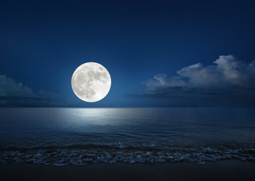 Full moon over the sea with tropical beach. (Elements of the moon image furnished by NASA)