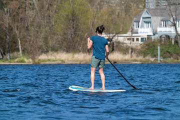 Issaquah, Washington State, USA. Woman standing to paddleboard. (Editorial Use Only)
