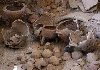 Recovered ancient pottery in prehistoric town of Akrotiri, excavation site of a Minoan Bronze Age settlement on the Greek island of Santorini - obrazy, fototapety, plakaty