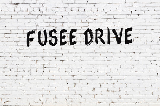 Inscription fusee drive painted on white brick wall