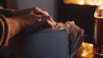Old documents and photos in directory, hands closeup view, looking for concept