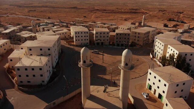 aerial shot of two mosques next to the main squere in an old empty city in the desert in palestine near Gaza at sunset.