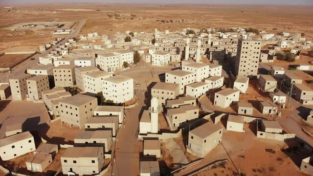 aerial shot of an old empty city in the desert in palestine near Gaza at morning while camera move around the buildings and the mosques next to the main squre of the city