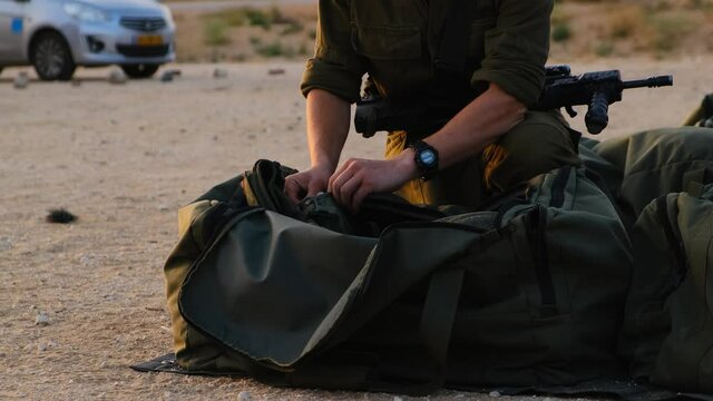 Close-up of soldiers hands prepare his equipment in his military bag ready to war