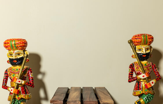 Handmade colorful wooden Rajasthani Doorkeeper or guard souvenir standing with plain background.